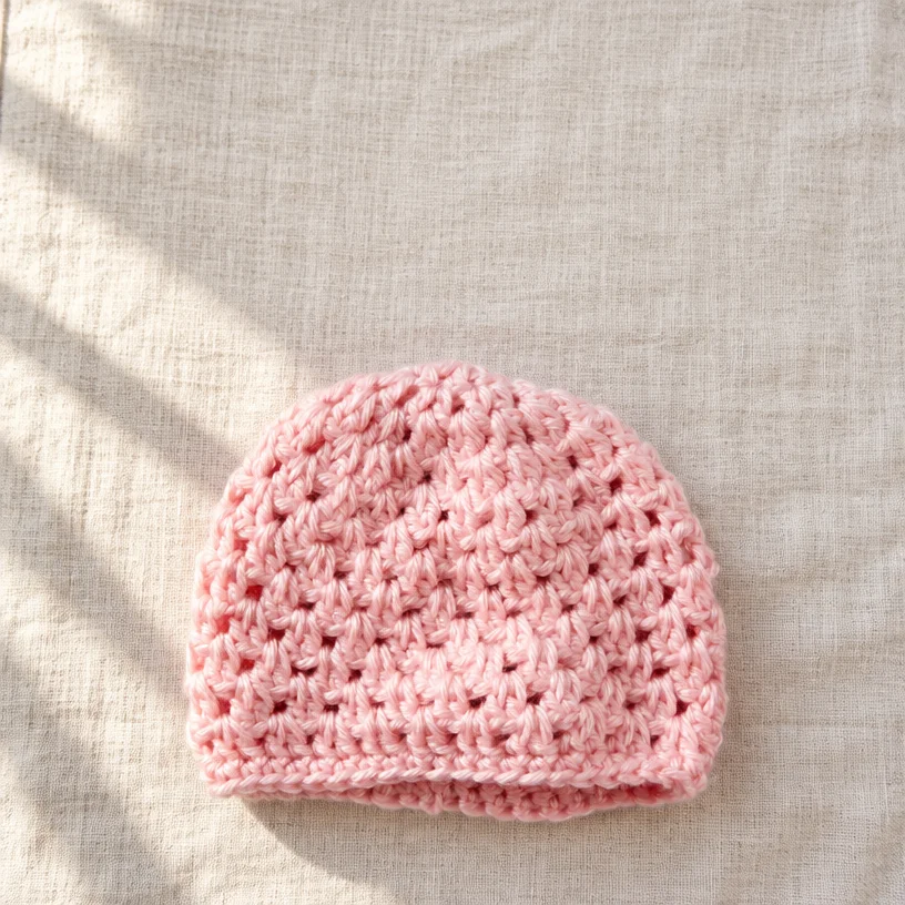 Baby crochet hat pattern featuring the First Cluster design for beginners